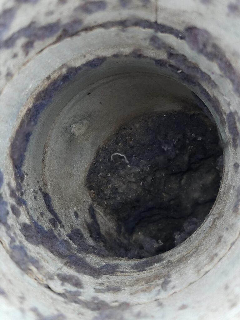 Lint buildup inside a dryer roof vent duct before cleaning